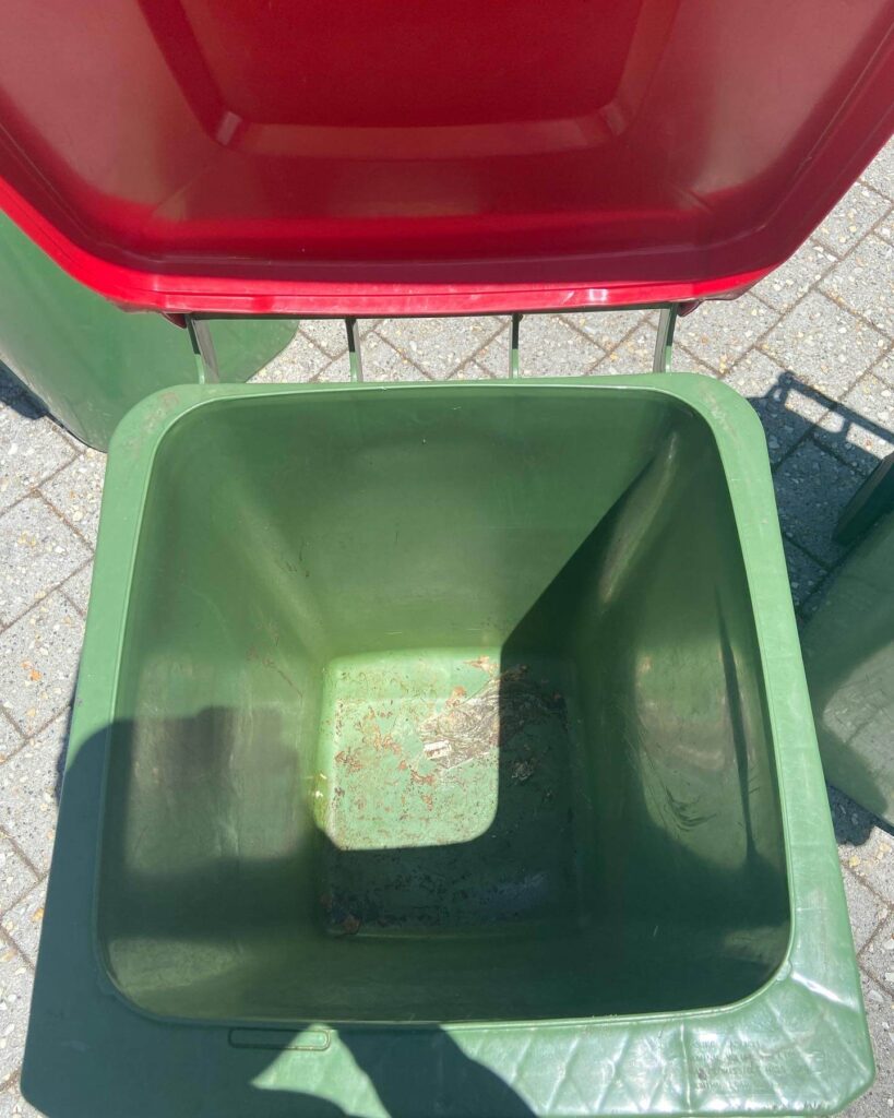 Green and red colored open dustbin with little dirt inside in Bin Cleaning Perth